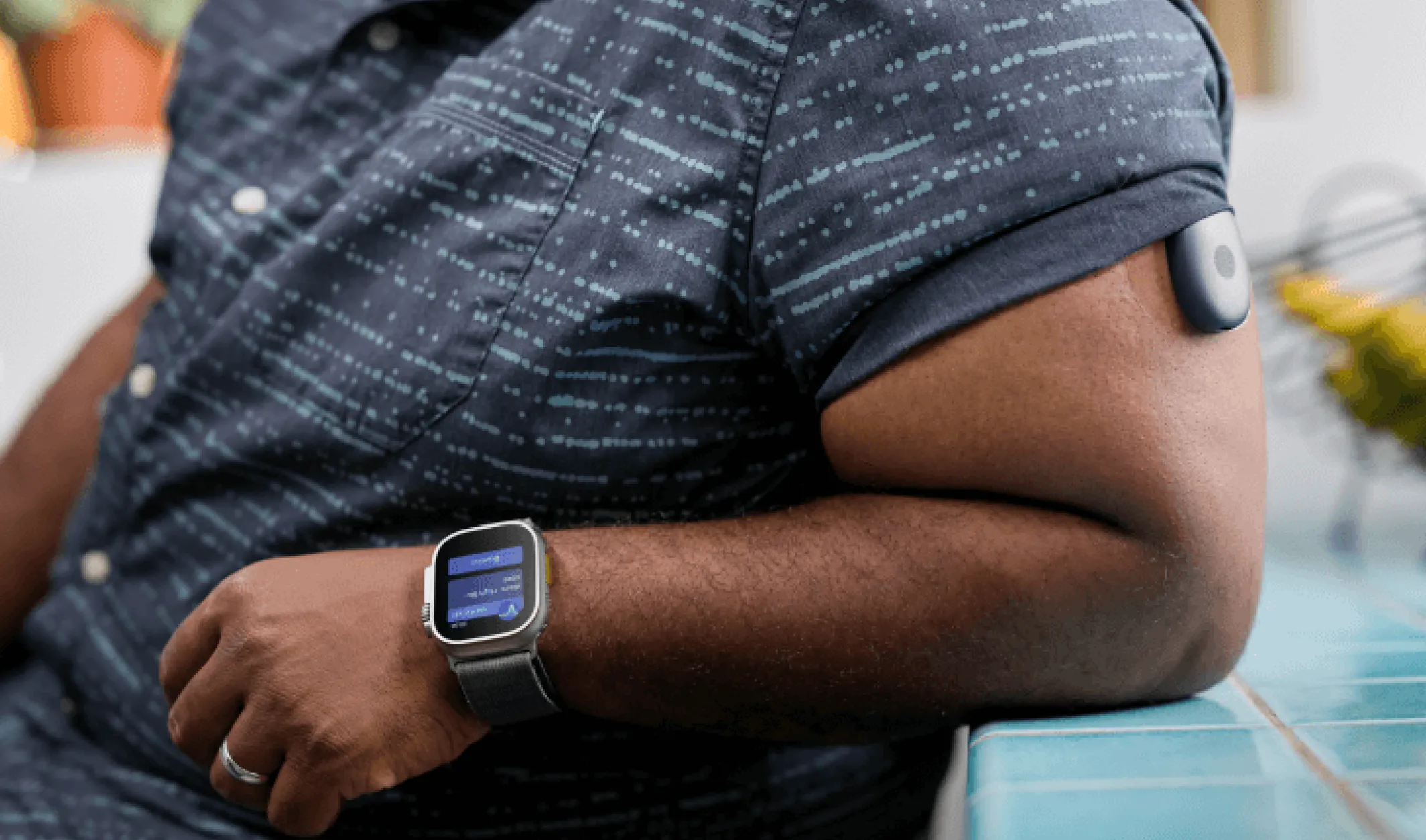 black mans arm close up with apple watch and eversense cgm sensor affixed to bicep
